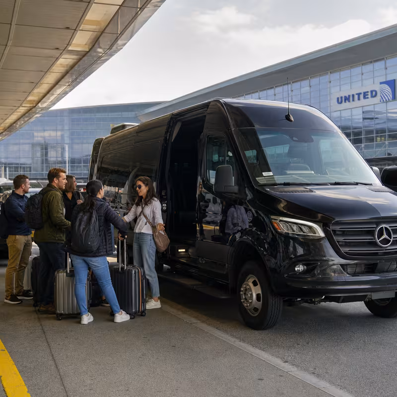 Group boarding a white charter bus for Airport Transportation transportation in San Francisco